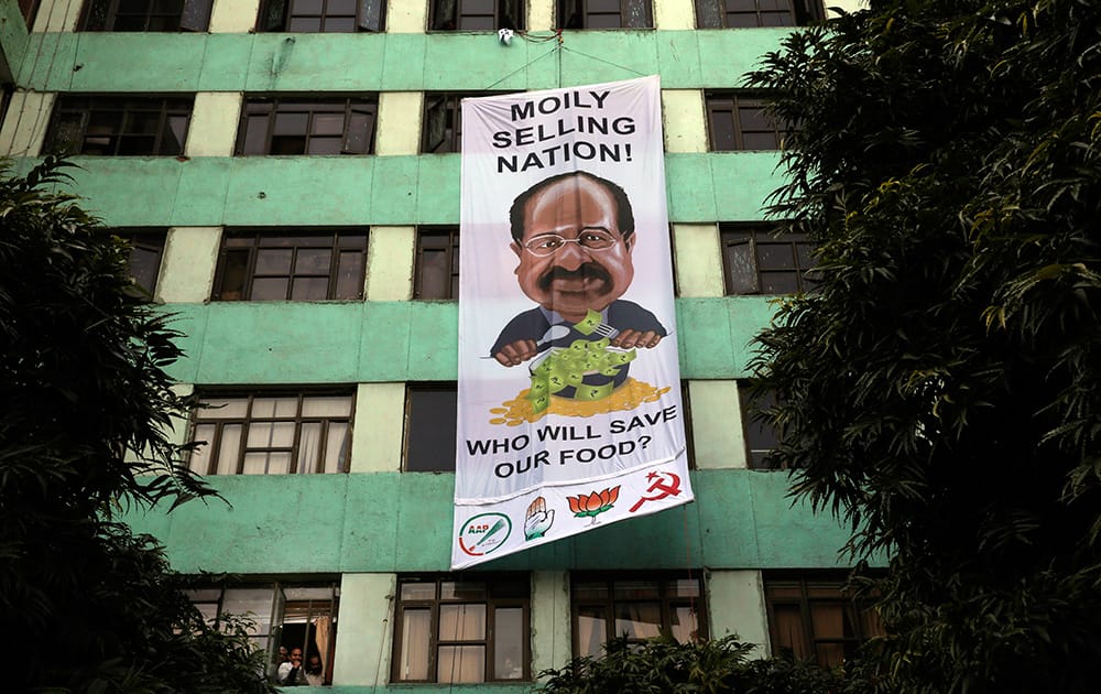 Greenpeace activists hang a giant banner with a caricature of Indian Minister for Environment and Forest Veerappa Moily on his office building as a sign of protest in New Delhi. The activists were protesting the Indian government’s decision to permit multinational seed companies field trial of genetically modified crops across the country.