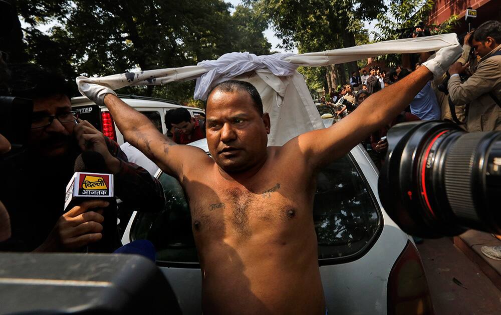 A lawyer removes his shirt after throwing ink on Chairman of Sahara India Pariwar Subrata Roy outside the Supreme Court in New Delhi.