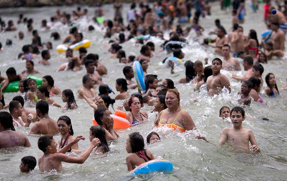 People swim in the ocean in La Guaira. Some Venezuelans are taking time off for carnival despite two weeks of nation-wide opposition protests.