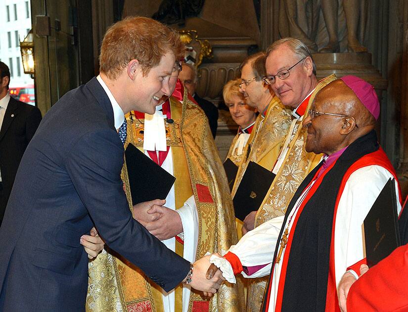 Britain`s Prince Harry, left, shakes hands with South African Archbishop Desmond Tutu as he arrives at Westminster Abbey in London for a memorial service to honour former South African president Nelson Mandela.