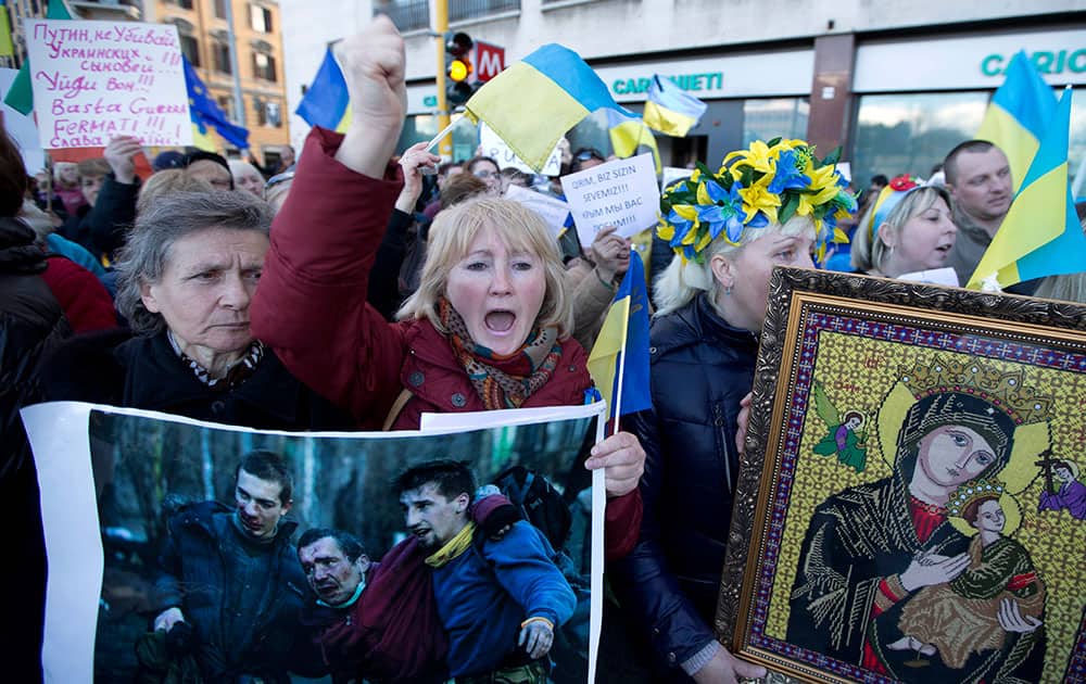 Ukrainians living in Italy shout slogans and hold a photo of what they say are victims of the unrest in Kiev, as they protest outside the Russian embassy, in Rome.