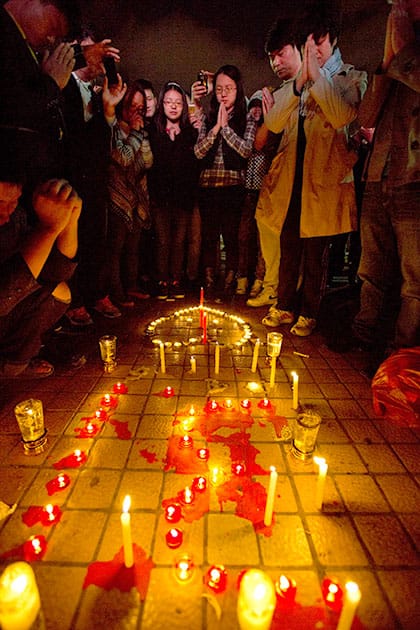 People light up candles and pray for the victims on a square outside the Kunming Railway Station where more than 10 assailants slashed scores of people with knives the night before in Kunming, in western China`s Yunnan province.