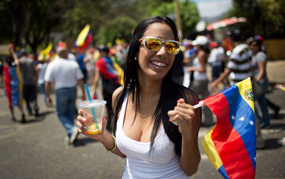 A woman marches with a represntation of Venezuela`s national flag during an anti-government demonstrator in Valencia, Venezuela.