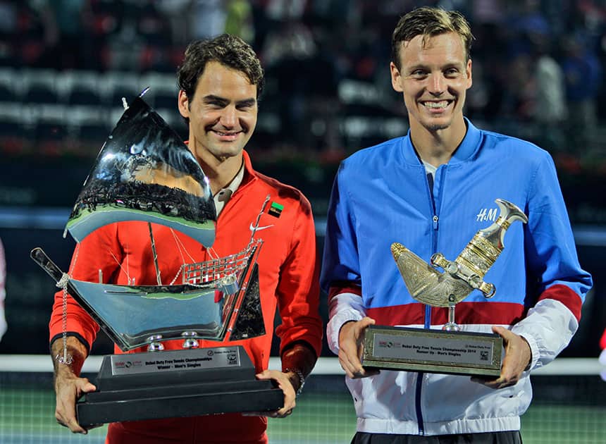 Roger Federer of Switzerland, left, and Tomas Berdych of Czech Republic display their trophies after Federer won the final match of the Dubai Duty Free Tennis Championships in Dubai, United Arab Emirates.