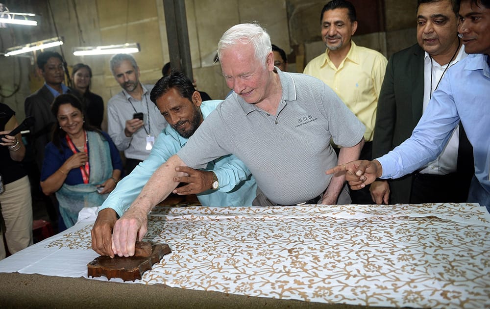 Canada`s Governor General David Johnston tries his hand at block printing with an Indian worker at a small factory in the Dharavi slum area of Mumbai.