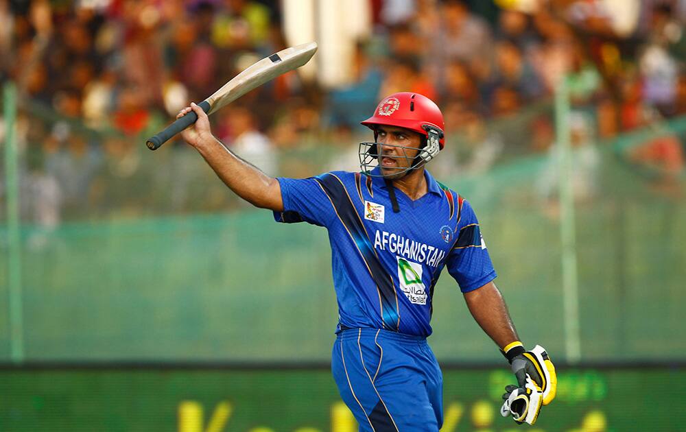Afghanistan’s Samiullah Shenwari acknowledges the crowd as he walks back to the pavilion after his dismissal during the Asia Cup one-day international cricket tournament against Bangladesh in Fatullah, near Dhaka, Bangladesh.
