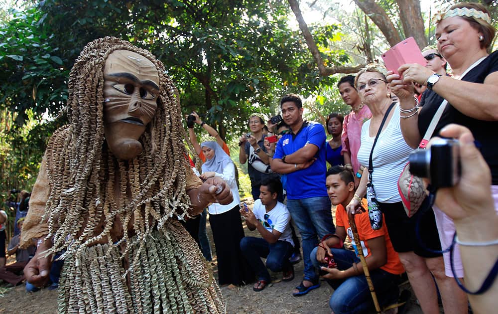 A Malaysia`s Mah Meri tribesman wearing a traditional wooden mask performs during the Ancestor`s Day celebration at Sungai Bumbun village in Carey Island, outside Kuala Lumpur, Malaysia.