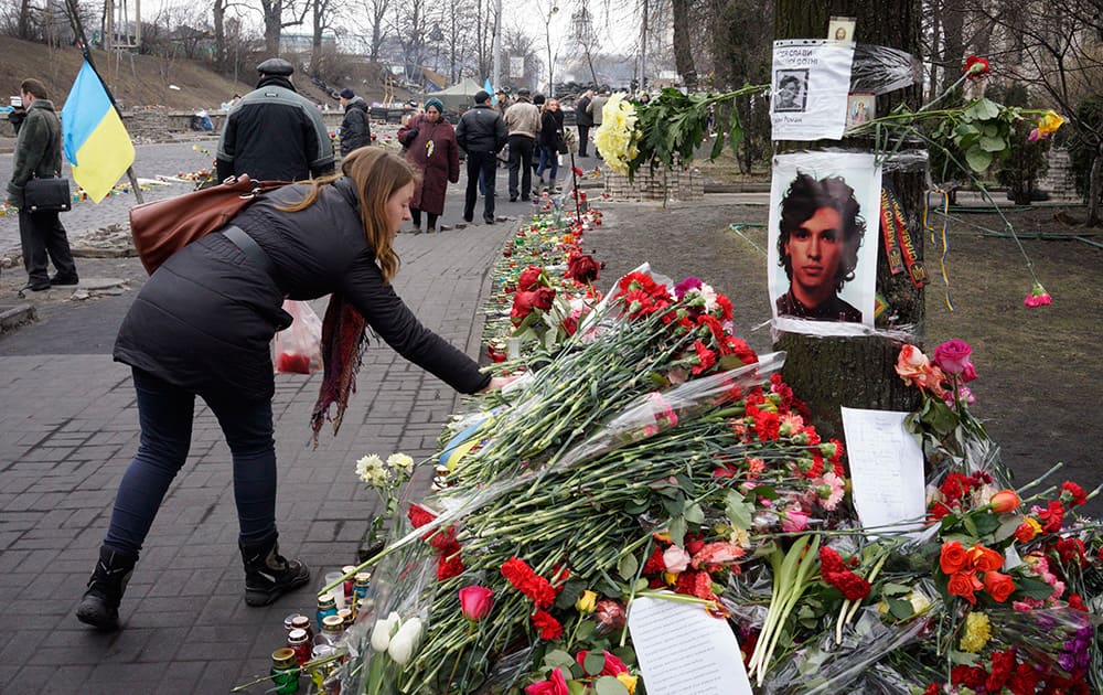 A woman lays flowers at the spot where a protester was killed in a recent clash with riot police in Kiev`s Independence Square, Ukraine.