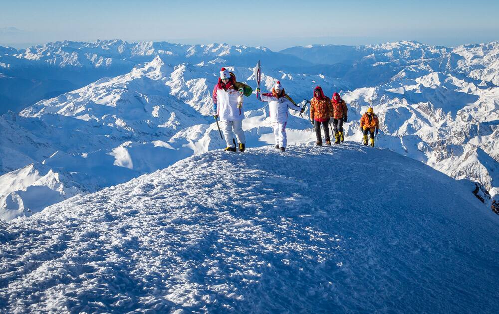 Mountain climber Karina Mezova, front, and Abdul-Khalim Elmezov, head of Kabardino-Balkaria climbing federation, head to light the Olympic flame on the summit of Mt. Elbrus during the Olympic torch relay in Kabardino-Balkaria province, southern Russia.