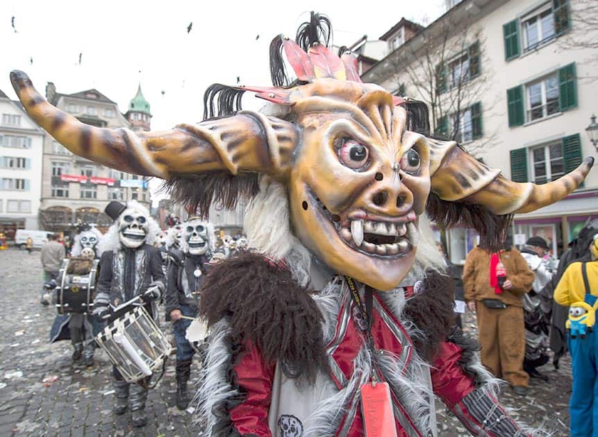 Revelers in carnival costumes attend the opening of the Lucerne carnival in Lucerne, Switzerland.