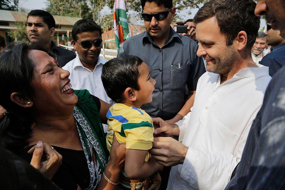 India’s ruling Congress party Vice President Rahul Gandhi, right, smiles as he interacts with a young child during his road show campaigning for the parliamentary elections, in Nagaon.