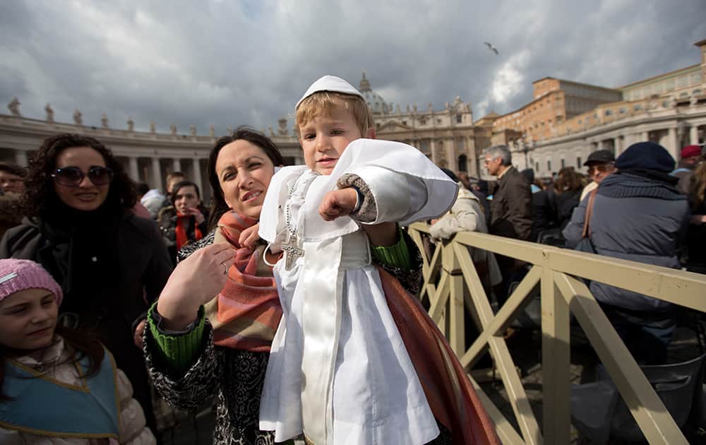 Paola Ciabattini holds up her 19-month-old son Daniele De Sanctis, dressed up as a pope, during Pope Francis` weekly general audience in St. Peter`s Square at the Vatican.