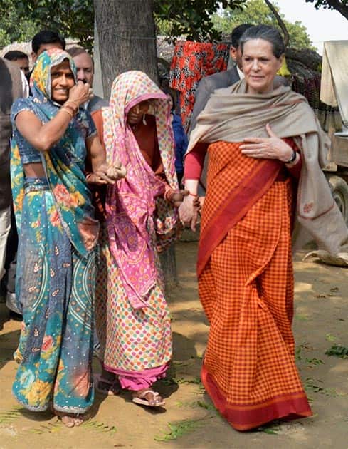 Congress President Sonia Gandhi walks with village women during a visit to her parliamentary constituency Raebareli.