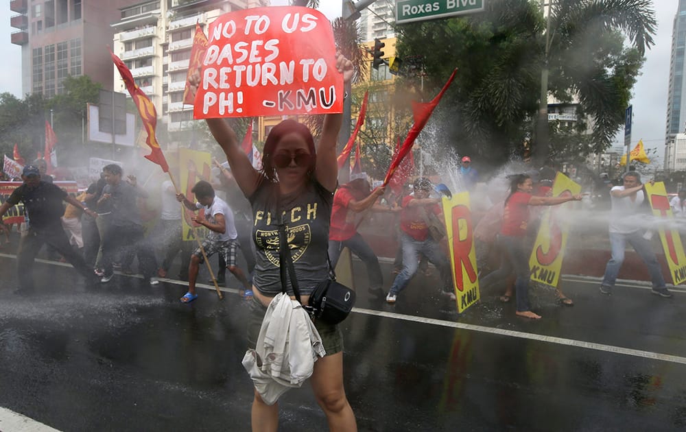 Firemen spray their water cannon at protesters who are forcing their way closer to US Embassy in Manila, Philippines during a protest against the forthcoming visit of US President Barack Obama.