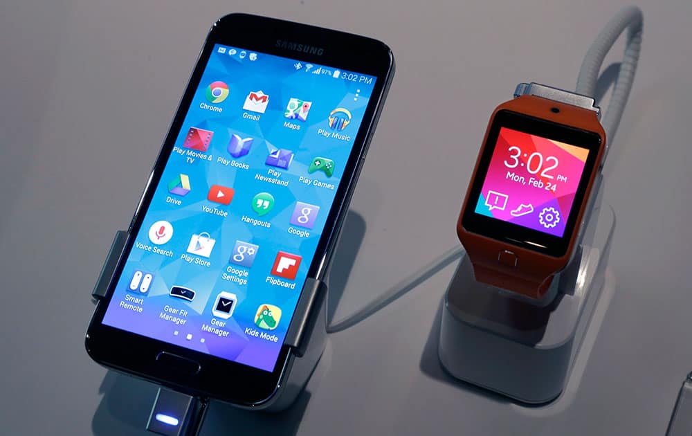 A Samsung Galaxy S5 smartphone, left, and a Samsung Gear 2 are displayed at the Samsung Galaxy Studio, in New York.
