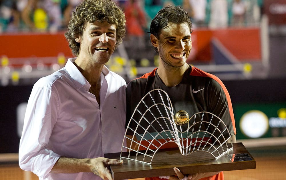 Spain`s Rafael Nadal, right, and Brazil`s former tennis player Gustavo Kuerten pose for a photo with Nadal`s trophy at the end of the Rio Open tournament in Rio de Janeiro, Brazil. Nadal returned from a troublesome back injury to win the Rio Open.