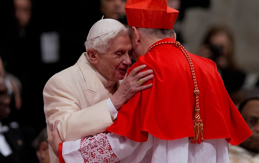 Newly-elected Cardinal Pietro Parolin is greeted by Pope Emeritus Benedict XVI after he received the red three-cornered biretta hat by Pope Francis during a consistory inside the St. Peter`s Basilica at the Vatican.