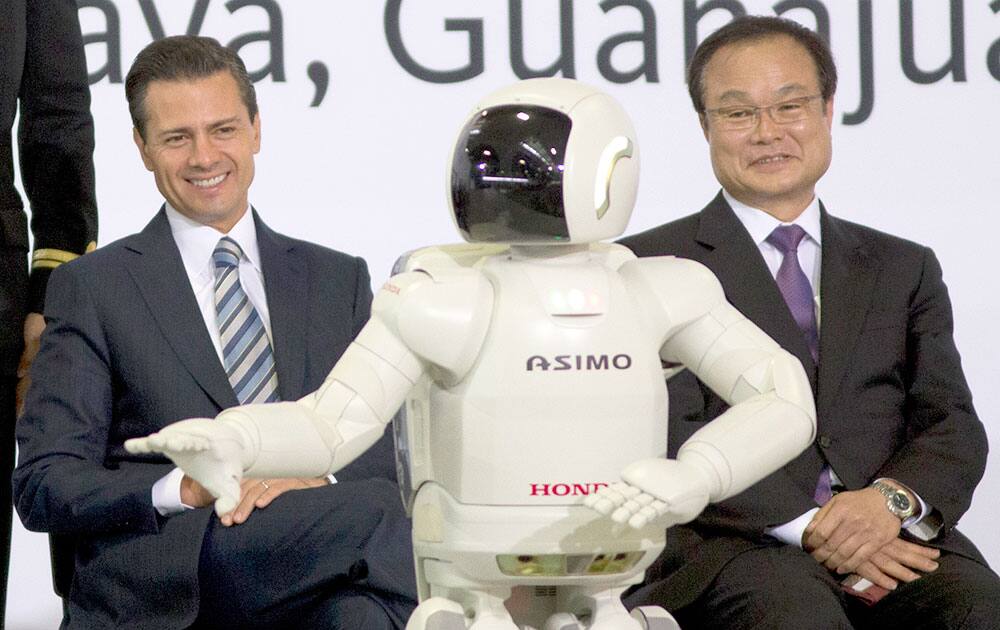 Mexico`s President Enrique Pena, left, and Honda Motor and CEO Takanobu Ito watch Hondo`s interactive robot Asimo during the inauguration of the new multibillion-dollar Honda car plant in Celaya, in the central Mexican state of Guanajuato.