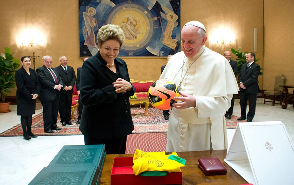 This photo provided by the Vatican newspaper L`Osservatore Romano, Pope Francis exchanges gifts with Brazilian President Dilma Rousseff during their audience at the Vatican.