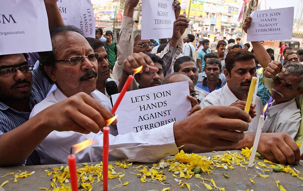 A man lights a candle during a condolence meeting on the 1st anniversary of twin bomb blast at Dilsukh Nagar in Hyderabad.