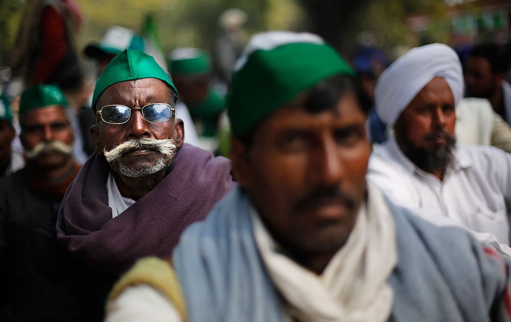Farmers listen to a speaker as they participate in a protest near the Indian Parliament in New Delhi. The farmers were protesting against government procuring land for setting up industries and not providing enough subsidy to farmers among several other grievances.