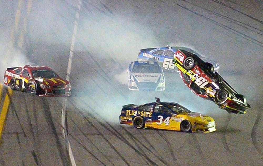 Clint Bowyer (15) flips over David Ragan (34) after a collision coming out of Turn 4 during the second of two NASCAR Sprint Cup qualifying auto races at Daytona International Speedway in Daytona Beach, Fla.