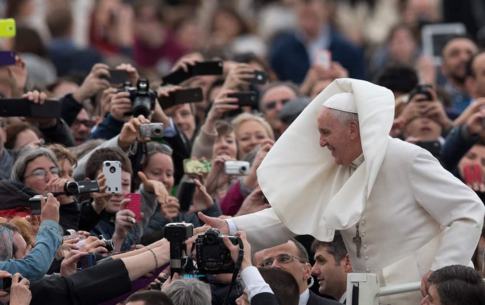 Pope Francis is greeted by the faithful as he tours St. Peter`s Square at the Vatican, prior to his general audience.