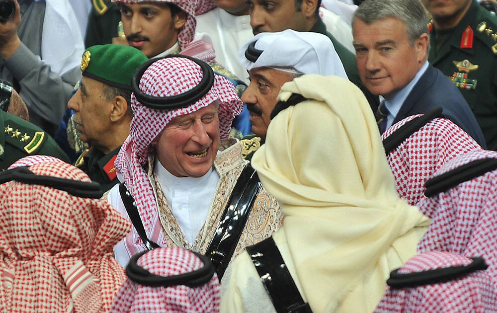Britain`s Prince Charles, center, wears traditional Saudi costume surrounded by Saudi Emirs and security officers, while he leaves the traditional Saudi dancing best known as `Arda` performed during Janadriya culture festival at Der`iya in Riyadh.