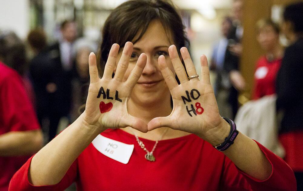 Beth Roth shows off messages written on her hands in opposition to a bill seeking to allow wedding vendors to deny services for same-sex ceremonies that was withdrawn in Senate committee in Nashville, Tenn.