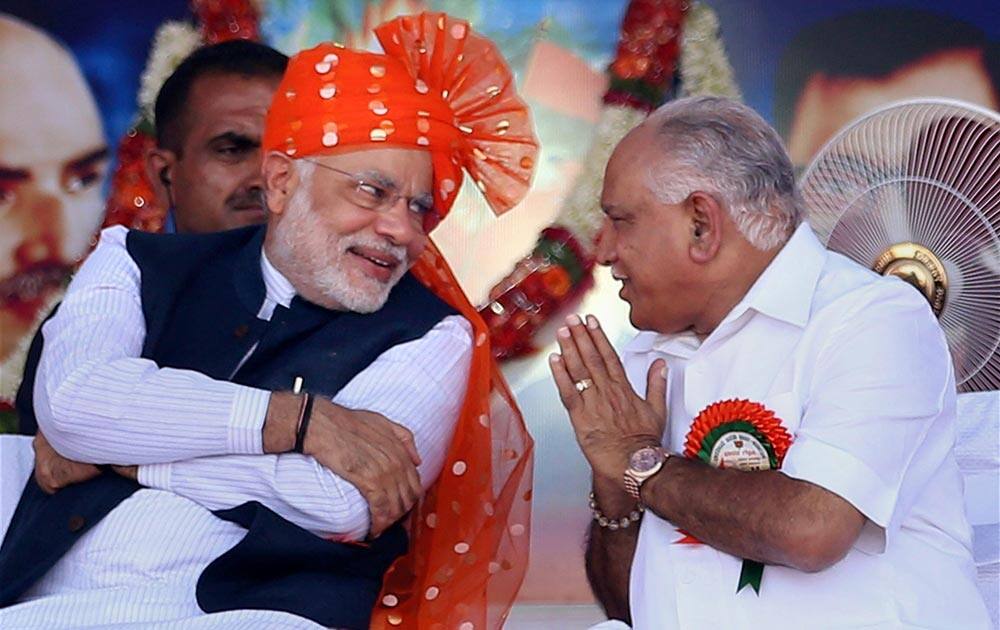 BJP Prime Ministerial Candidate and Gujarat CM Narendra Modi interacts with former CM of the state B.S Yeddyurappa at a rally in Davangere, Karnataka.