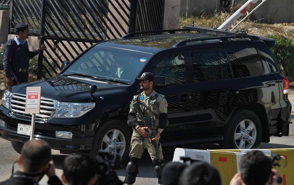 A paramilitary soldier stands guard as the vehicle of former Pakistani President Pervez Musharraf leaves after his court appearance in Islamabad, Pakistan.