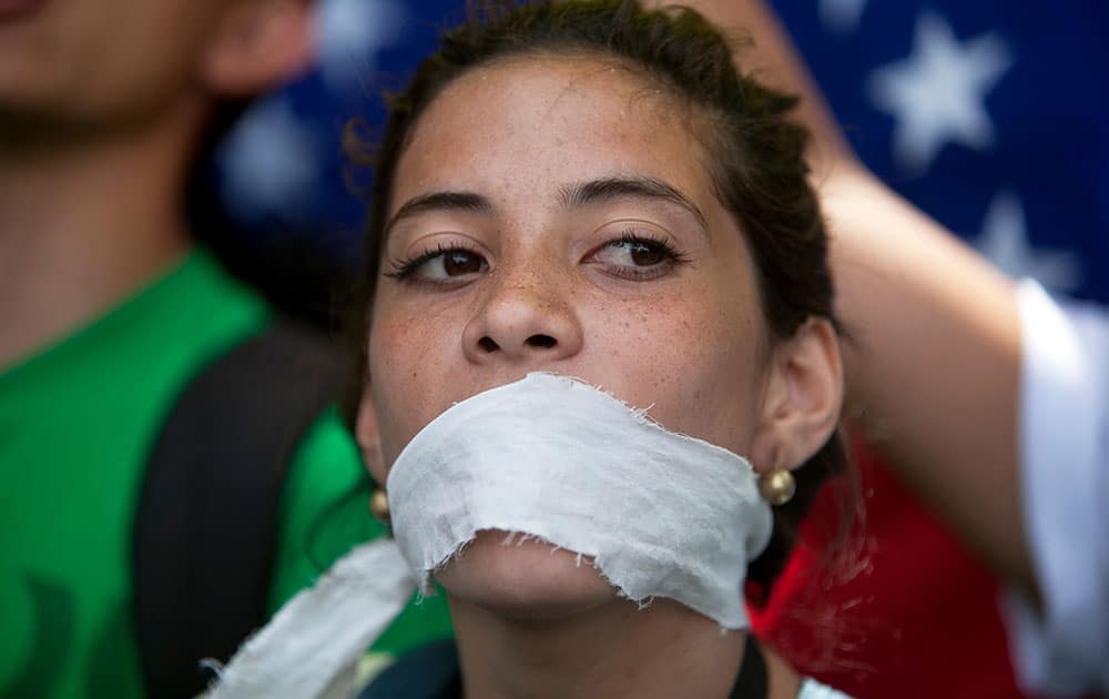 A demonstrator covers her mouth with a rag to prostest government censorship, during a march to Venezuelan Telecommunications Regulator Office or CONATEL in Caracas, Venezuela.