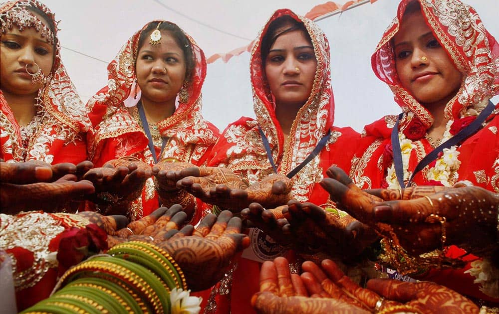Brides from the Muslim community showing their heena decorated hands during a mass marriage ceremony in Ahmedabad.