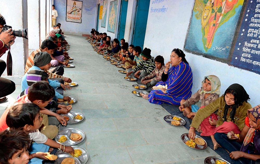 Rajasthan Chief Minister Vasundhara Raje having meals with school children during her visit in Dholpur, Rajasthan.