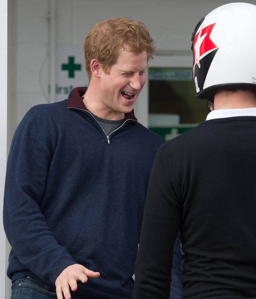 Britain`s Prince Harry, gestures, during his visit to the Goodwood Motor Circuit, in Chichester, England. The prince attended a track day for the Royal Foundation Endeavour Fund, and joined injured services personnel to drive classic cars.