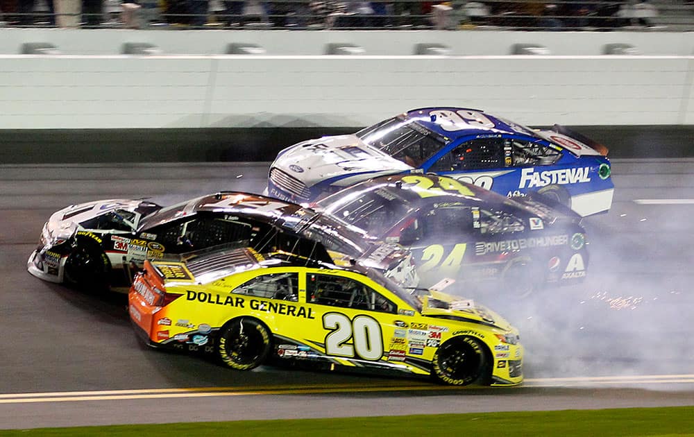 Matt Kenseth (20) slides backward as he is involved in a crash with Tony Stewart (14), Jeff Gordon (24) and Carl Edwards (99) on the front stretch during the NASCAR Sprint Unlimited auto race at Daytona International Speedway in Daytona Beach, Fla.