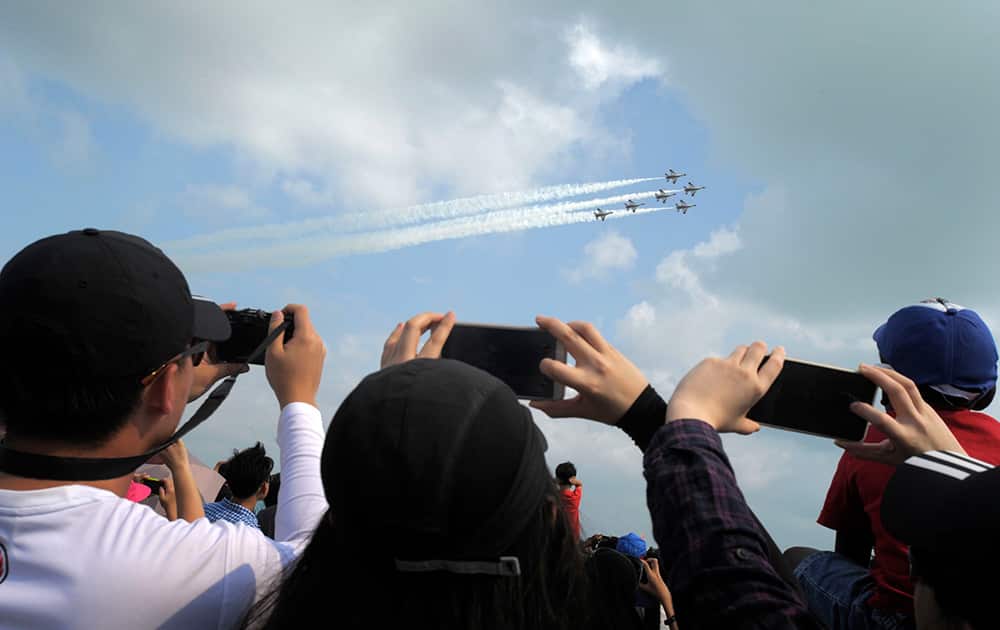 The F16 jets of Singapore Air Force aerobatics team the Black Knights perform a maneuver during the Singapore Airshow in Singapore.