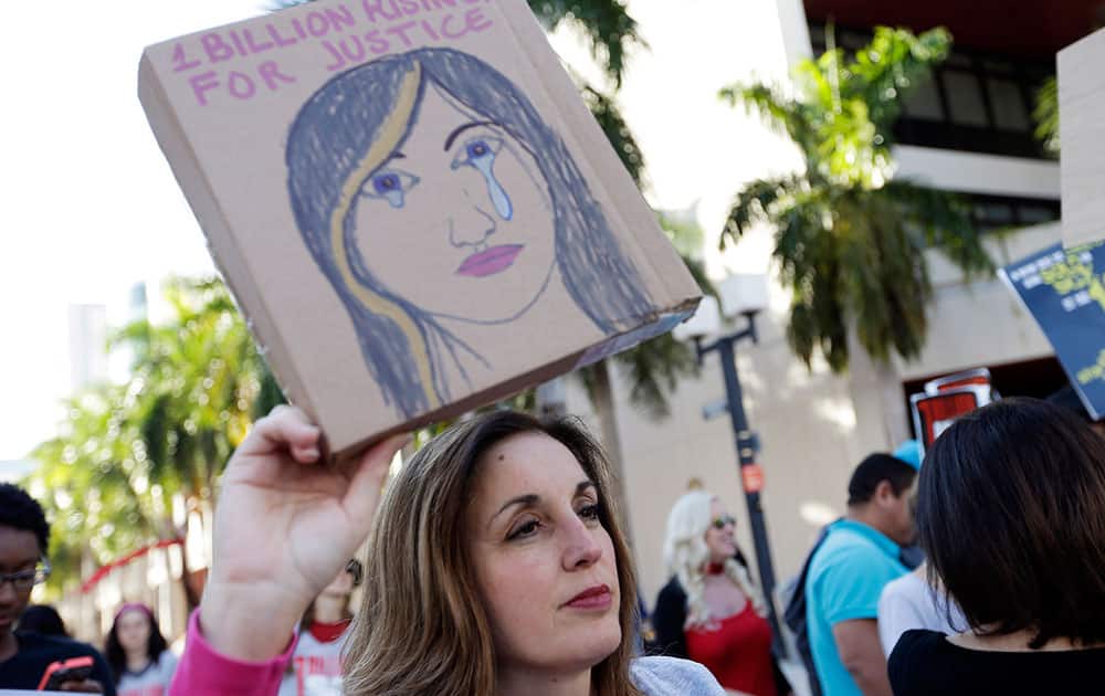 Lynette McGuinness holds a sign during a rally against human trafficking, in Miami. This event was part of the One Billion Rising for Justice, a worldwide event by supporters demanding the arrest of those who participate in domestic violence and human trafficking.
