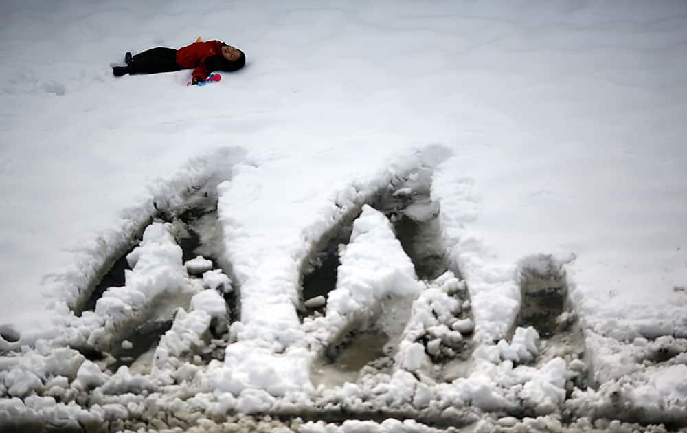 A child plays at a parking lot covered with snow in Yokohama, Japan, as the Pacific coast of eastern and western Japan was hit by snow.