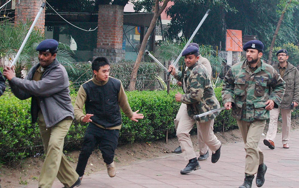 Securitymen charge Northeast students near Parliament during a protest over the killing of Nido Tania in New Delhi.