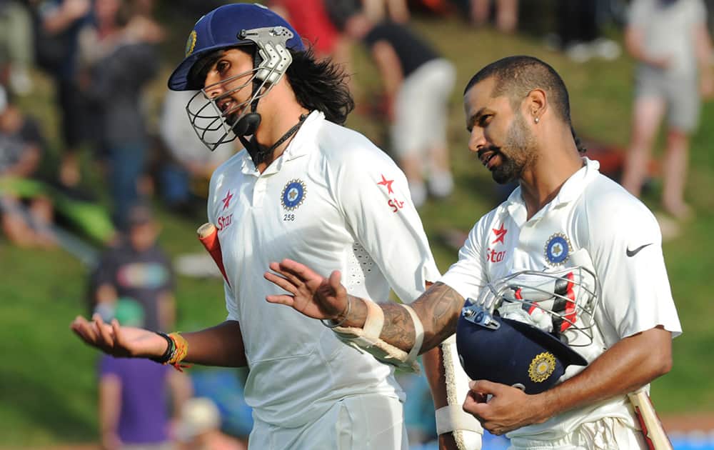Ishant Sharma and Shikar Dhawan leave the pitch at the end of play against New Zealand on the first day of the second cricket test in Wellington, New Zealand.