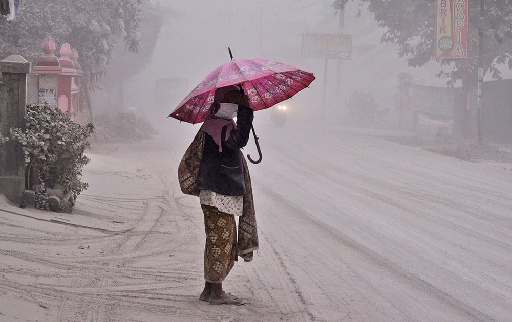 A women walks on a road covered with volcanic ash following an eruption of Mount Kelud, in Yogyakarta, Indonesia.