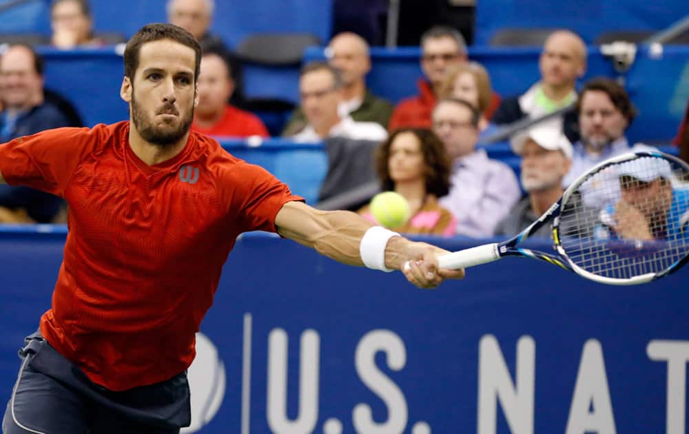 Feliciano Lopez, of Spain, stretches to return the serve of Ivo Karlovic, of Croatia, in a U.S. National Indoor Tennis Championships match.