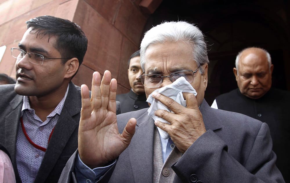 An unidentified member of India`s Parliament covers his face with a handkerchief after being affected by pepper spray gas in New Delhi.