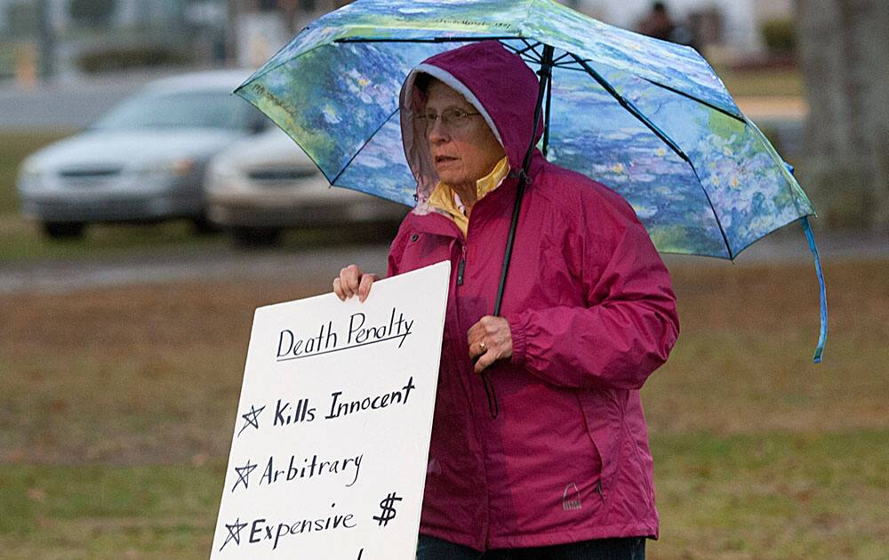 A demonstrator against the death penalty braves the rain at the Florida State Prison near Starke, Fla., just hours before the execution of Juan Carlos Chavez.