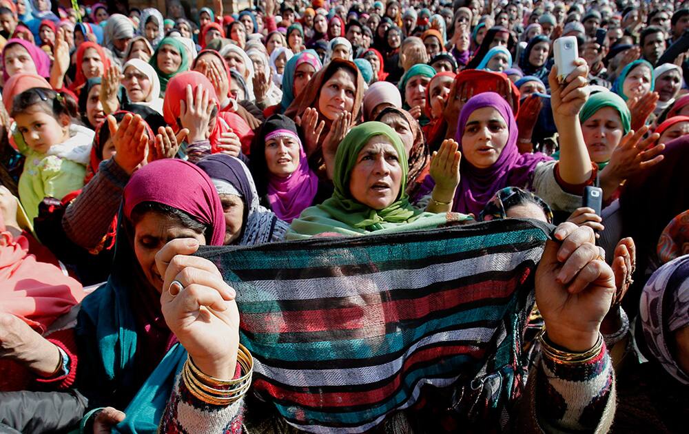 Kashmiri Muslim devotees pray as the head priest displays a relic of Sufi Saint Syed Abdul Qadir Jilani outside his shrine in Srinagar.