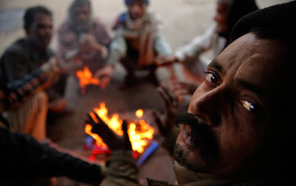 Men warm themselves around a fire on a cold morning in the old quarters of New Delhi. The capital witnessed a chilly morning Wednesday.