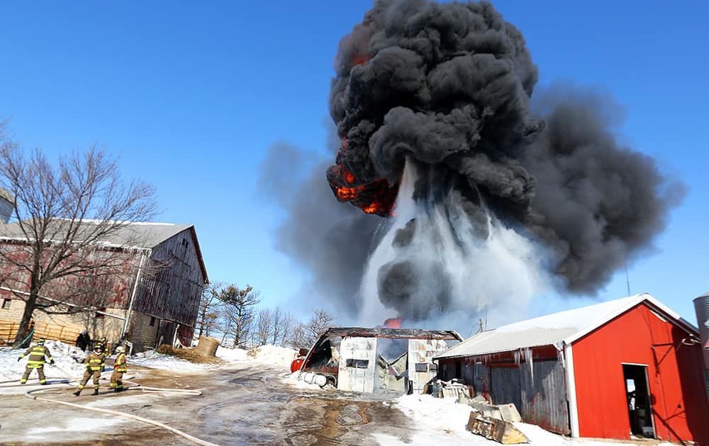 An explosion backs up the Cascade, Iowa, fire and rescue workers trying to contain a machine shed fire on the Richard and Jerald Reiter farm on Reiter Road, just off US 151 and near North Cascade Road, Tuesday morning.