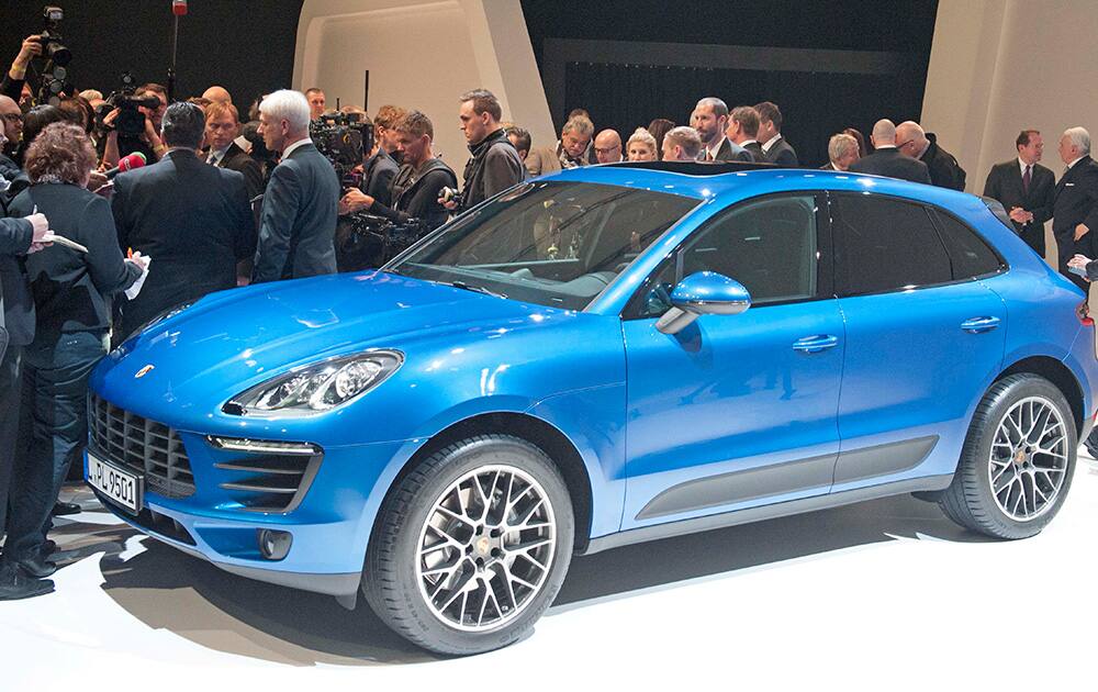 People gather around the new Porsche Macan car during a ceremony marking the official production start of the new Porsche Macan in the Porsche AG factory in Leipzig, Germany.