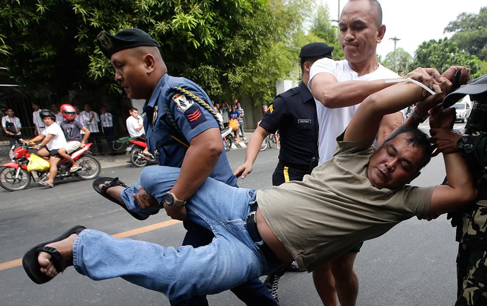 Presidential security arrest a farmer-protester after their group was able to sneak into the tight security to hold a `lightning rally` right at the gates of Malacanang Palace in Manila, Philippines to demand the President award them the farmlands allegedly promised them through the Comprehensive Agrarian Reform Program of the government.